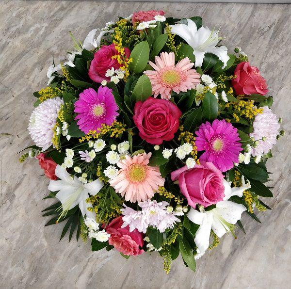 Arrangement with various beautiful flowers in pink and red colour